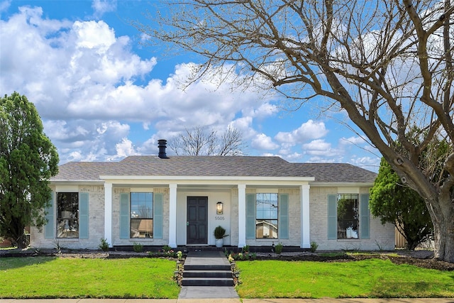 view of front of house with a shingled roof and a front yard