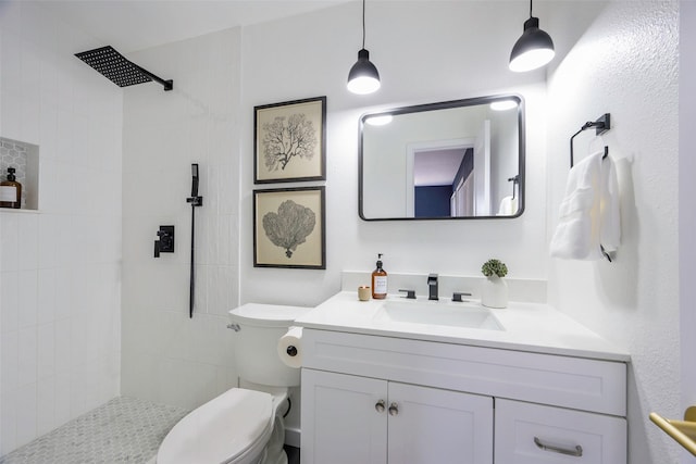 full bathroom featuring vanity, toilet, and a tile shower