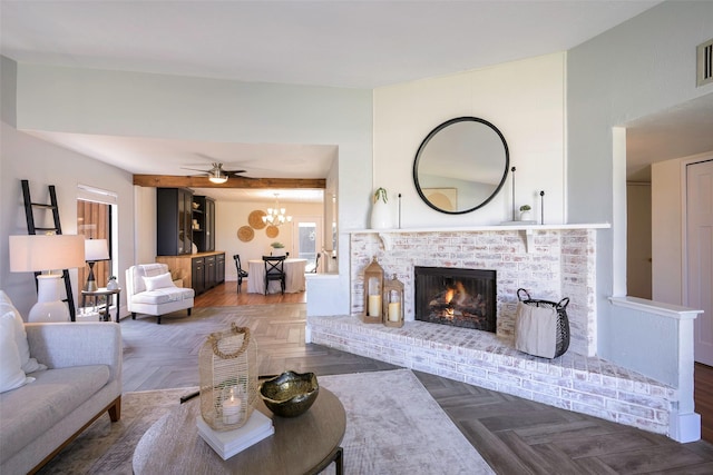 living room featuring visible vents, a fireplace, and ceiling fan with notable chandelier