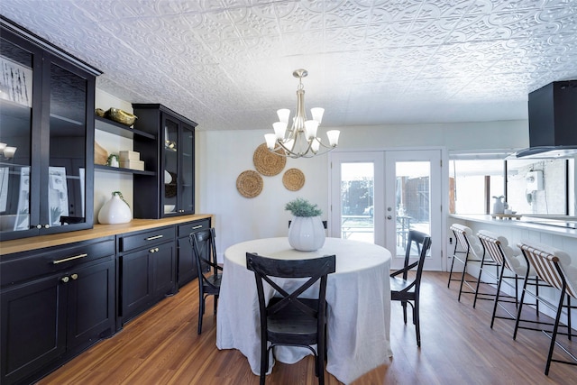 dining room featuring a notable chandelier, french doors, and wood finished floors