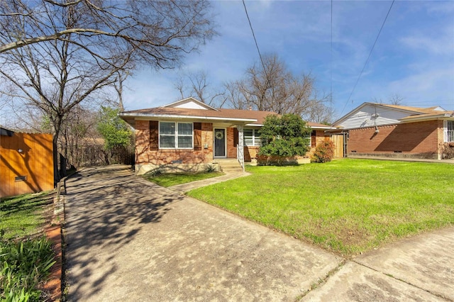 view of front of home with fence, a front lawn, and brick siding