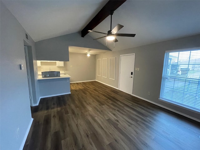 unfurnished living room featuring dark wood-style floors, lofted ceiling with beams, a ceiling fan, and baseboards