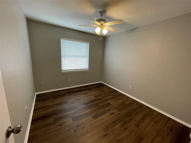 empty room featuring ceiling fan, dark wood finished floors, and baseboards