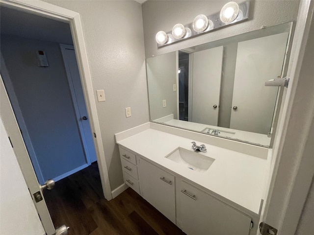 bathroom with vanity, baseboards, and wood finished floors