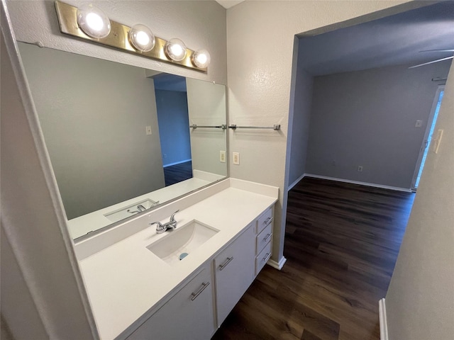 bathroom featuring wood finished floors, vanity, and baseboards