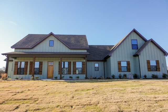 modern farmhouse featuring a front lawn, board and batten siding, and a shingled roof