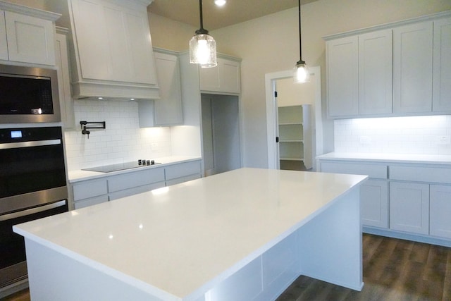 kitchen featuring a center island, dark wood finished floors, custom exhaust hood, stainless steel appliances, and backsplash