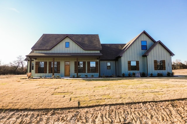 modern farmhouse style home with roof with shingles, board and batten siding, and a front yard