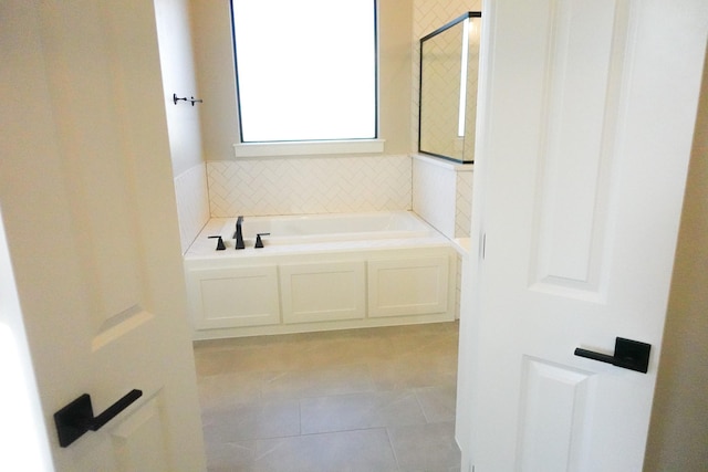 bathroom with a bath and tile patterned floors