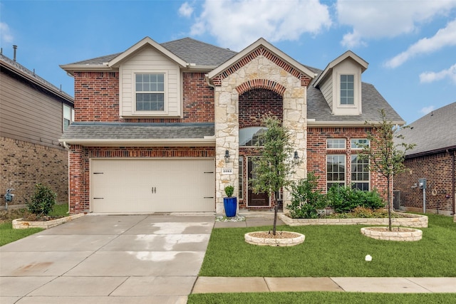 view of front of house with brick siding, roof with shingles, concrete driveway, a front yard, and stone siding