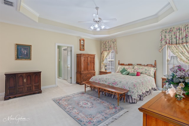 bedroom featuring light carpet, visible vents, a raised ceiling, and ornamental molding