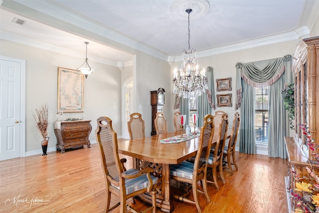 dining space featuring crown molding, visible vents, light wood-style flooring, an inviting chandelier, and baseboards