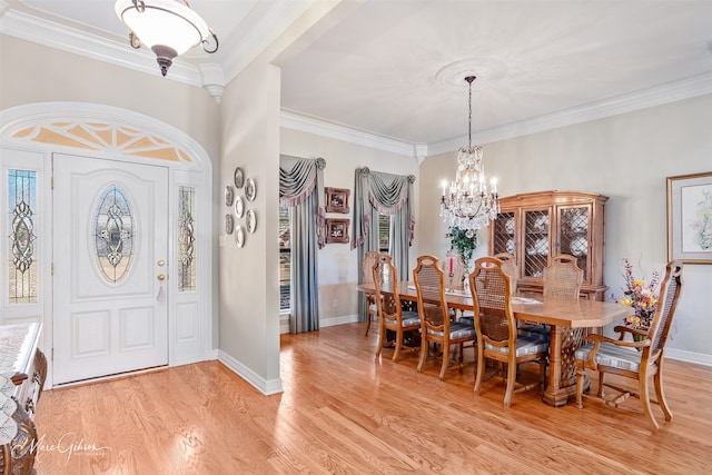 dining room featuring an inviting chandelier, baseboards, ornamental molding, and light wood-style floors