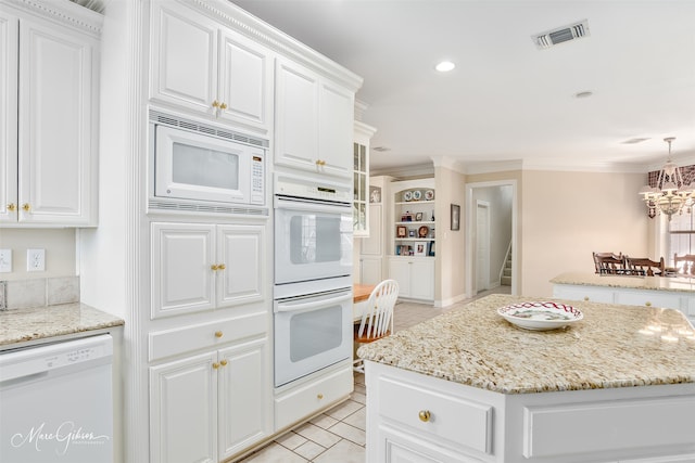 kitchen with white appliances, light tile patterned floors, visible vents, ornamental molding, and white cabinetry