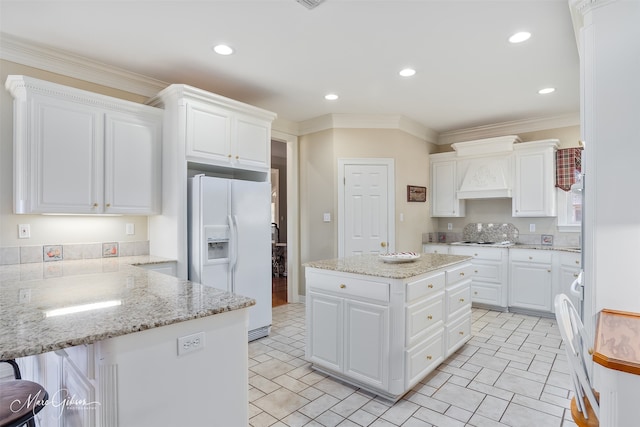 kitchen featuring ornamental molding, white appliances, white cabinetry, and a peninsula