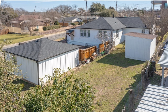 view of yard featuring a storage shed, a fenced backyard, a residential view, and an outdoor structure