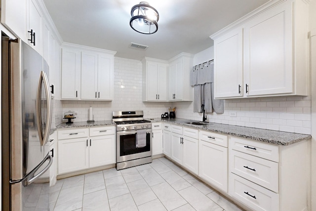 kitchen featuring stainless steel appliances, a sink, visible vents, white cabinets, and backsplash