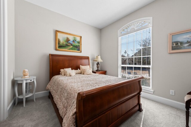 bedroom featuring light carpet, baseboards, and multiple windows