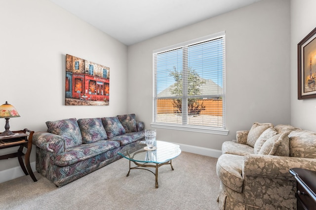 carpeted living area featuring baseboards