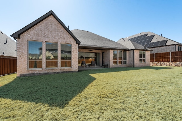 back of house with a patio area, a fenced backyard, a lawn, and brick siding