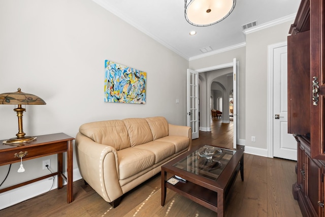 living room with arched walkways, visible vents, baseboards, dark wood-style floors, and crown molding