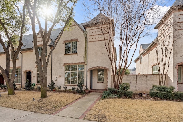 view of front of home featuring brick siding and fence