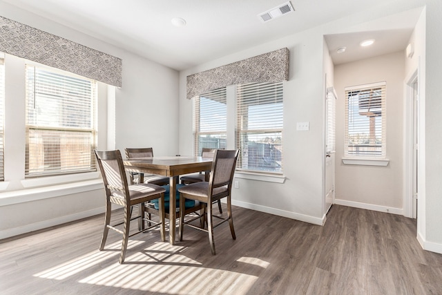 dining area featuring baseboards, visible vents, and wood finished floors