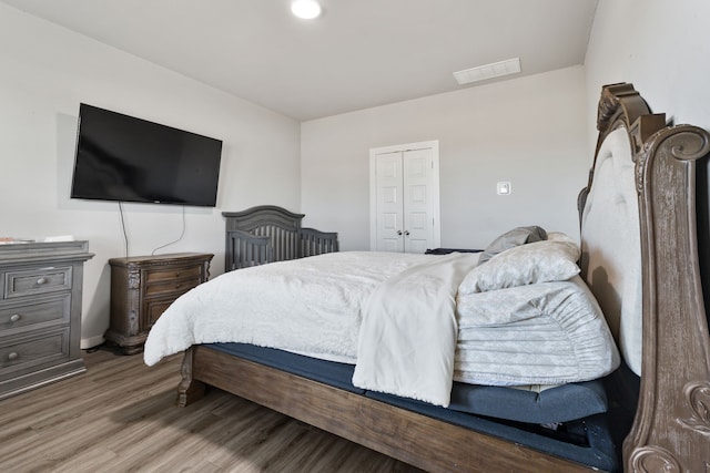 bedroom featuring visible vents and wood finished floors