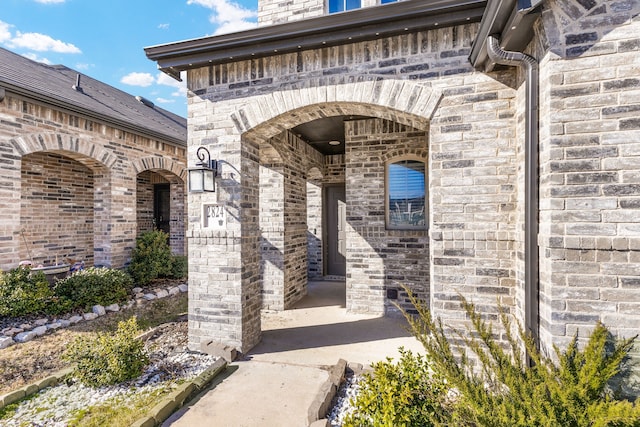 doorway to property featuring brick siding