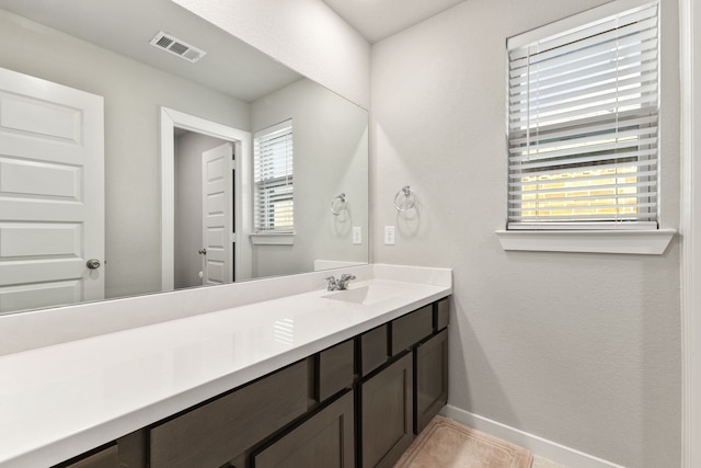 bathroom featuring baseboards, visible vents, and vanity