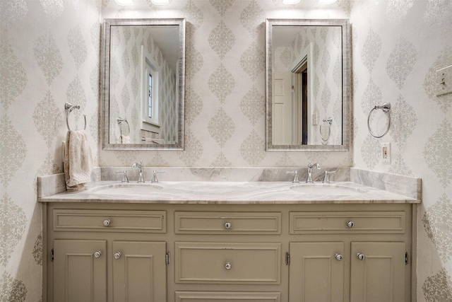 bathroom featuring double vanity, a sink, and wallpapered walls