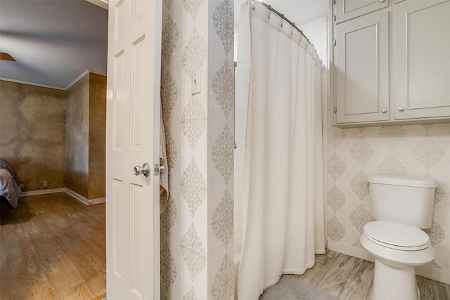 bathroom featuring curtained shower, wood finished floors, toilet, and baseboards