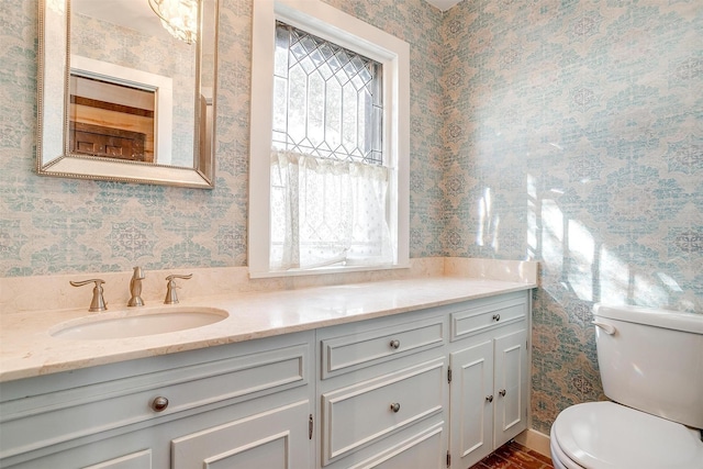 bathroom featuring toilet, wallpapered walls, and a healthy amount of sunlight