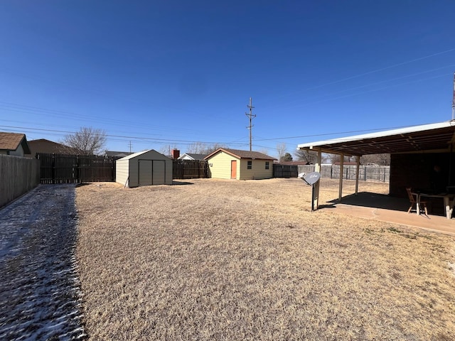 view of yard with a shed, an outdoor structure, and a fenced backyard