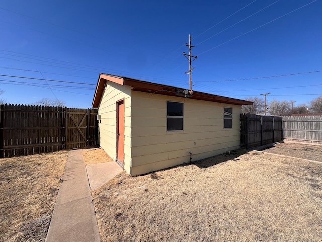 view of outdoor structure with a fenced backyard and an outbuilding