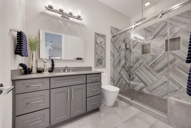 bathroom featuring toilet, a shower stall, and vanity