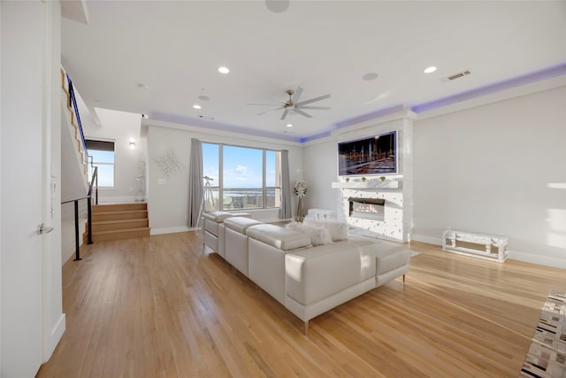 living area featuring visible vents, stairway, a stone fireplace, recessed lighting, and light wood-style floors