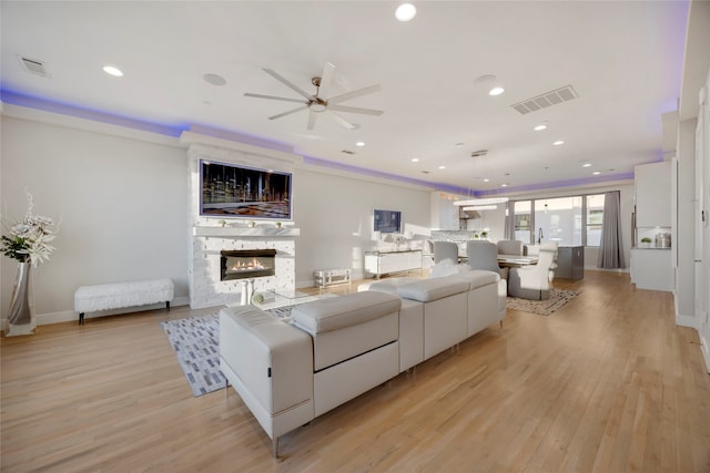 living room with recessed lighting, visible vents, light wood-style flooring, and a fireplace