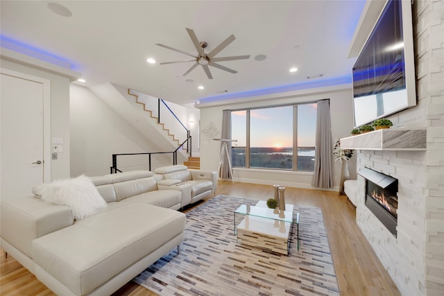 living area featuring a ceiling fan, recessed lighting, stairway, light wood-style floors, and a fireplace