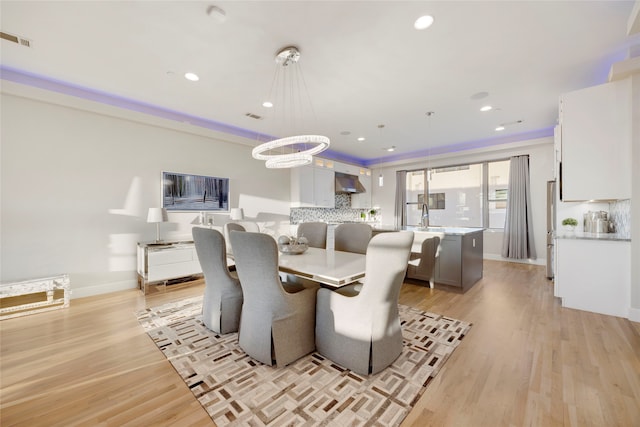 dining space featuring light wood-style flooring, recessed lighting, visible vents, and baseboards