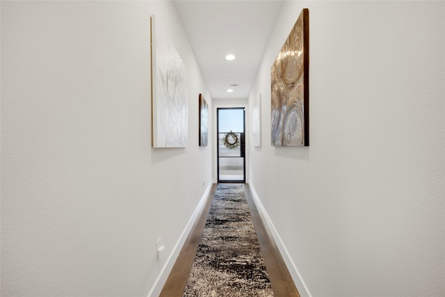 hallway featuring dark wood-style floors, recessed lighting, and baseboards