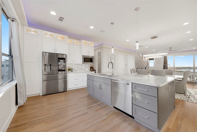 kitchen featuring visible vents, gray cabinetry, a sink, white cabinets, and appliances with stainless steel finishes