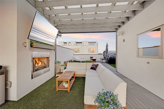 interior space with a balcony, a pergola, and a lit fireplace