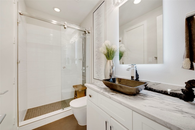 bathroom with recessed lighting, a shower stall, toilet, and vanity