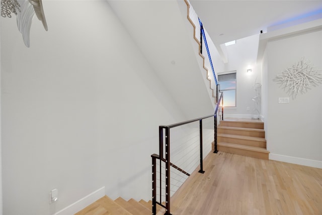 stairway with wood finished floors and baseboards