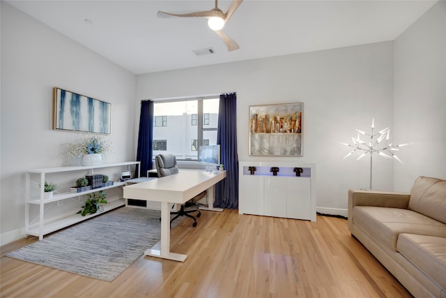 office with baseboards, visible vents, a ceiling fan, and light wood-style floors