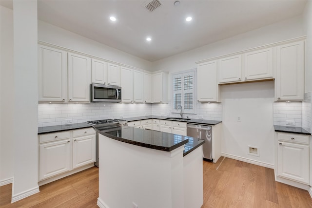 kitchen featuring a sink, stainless steel appliances, light wood-style floors, visible vents, and white cabinetry