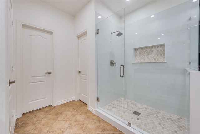 bathroom featuring baseboards, a stall shower, and tile patterned floors