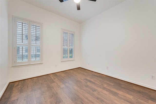 empty room featuring a healthy amount of sunlight, ceiling fan, baseboards, and wood finished floors