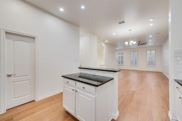 kitchen featuring light wood finished floors, visible vents, dark countertops, white cabinetry, and recessed lighting